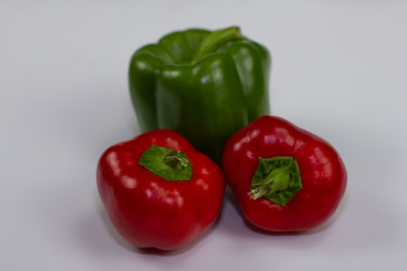 Multi-colored bell peppers lie on a white background for food shooting. Fresh vegetables just picked from the farmers garden. Multi-colored juicy peppers are very healthy and tastyの写真素材