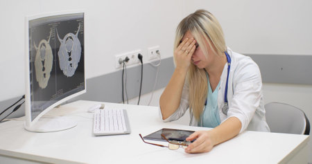 Veterinarian woman in depression sits at the table. The doctor is exhausted and desperately trying to find a solution. A lot of work as a veterinarian leads to emotional burnout.の写真素材