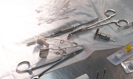 Close-up. Sterile surgical instruments lie on the table in disarray while the doctor is working....