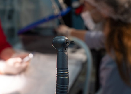 Detailed close-up photo of a dental drill against the background of an operating room. The dentist holds a dental drill in his hands. Ready-to-use dental drill.の写真素材