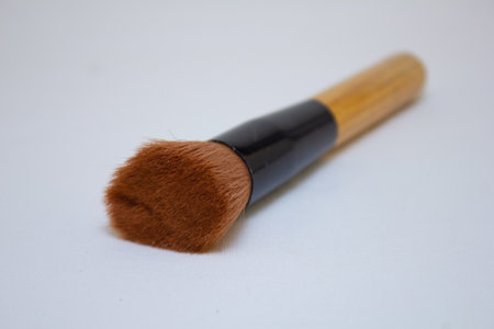 Makeup brush isolated on white background. Close-up. A fluffy face brush for applying blush with a wooden handle. Facial care and makeup concept.の写真素材