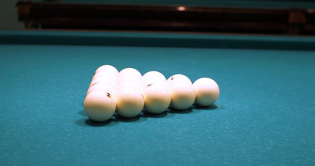 Triangle pyramid of white billiard balls in the middle of a green table. The beginning of the game...