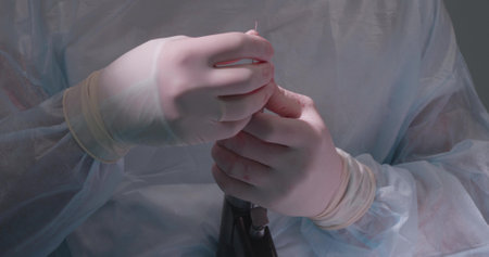 A veterinary surgeon in the operating room inserts a drill into a medical drill and prepares for osteosynthesis. The surgeon is holding a medical drill in the operating room in uniform.の写真素材