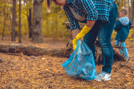 Mother and son eco activists collect garbage in the forest The family takes care of saving the...
