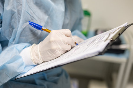 Close-up The anesthesiologist records the progress of the operation on a tablet while standing in the operating room Wearing an operating gown the anesthesiologist describes the operation in a chart.の写真素材