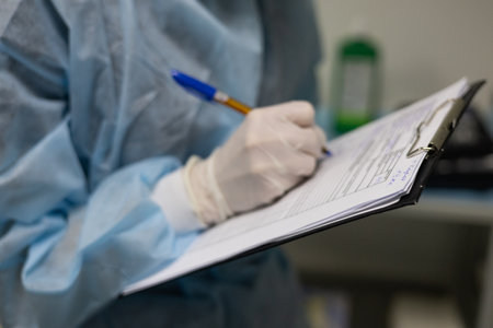 Holding a tablet in his hands, the veterinary anesthesiologist makes notes in the patients chart. During surgery, the anesthesiologist describes the patients condition on a tablet.の写真素材