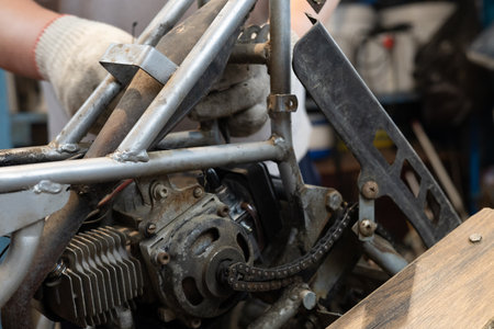 A father is repairing his sons ATV in the garage. Repairing an ATV yourself in the garage using a...