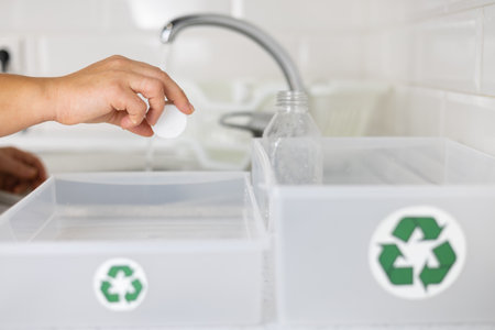 Zero waste Sorting plastic. A woman cleans plastic bottles under water and places them in a...