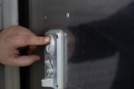 A hand puts a coin into a machine at a car wash. Close-up of a man inserting a coin into a machine...