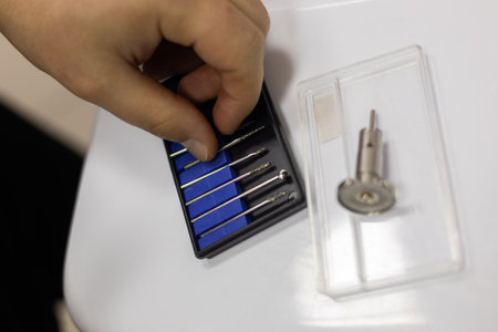 A veterinarian selects a drill from a variety of surgical instruments, prepares for surgery on a pet...
