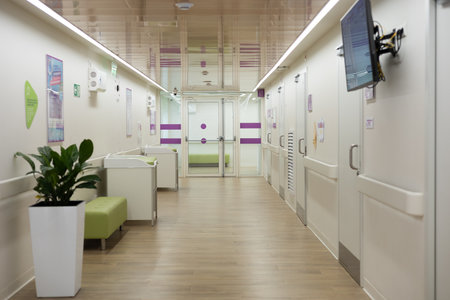 Modern hospital corridor with changing tables, waiting area, and closed doors leading to examination rooms, emphasizing hygiene and child-friendly design.の写真素材