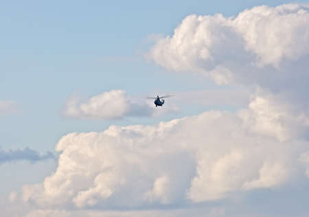 Helicopter in the cloudy sky の写真素材