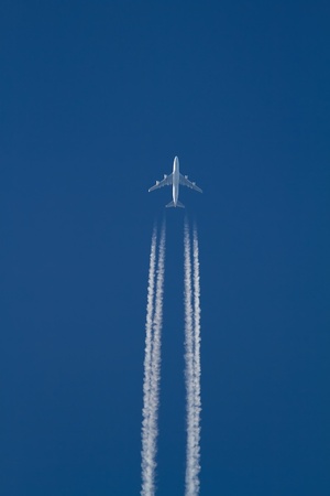 A jumbo-jet leaves trails of exhaust gas while flying at high altitude