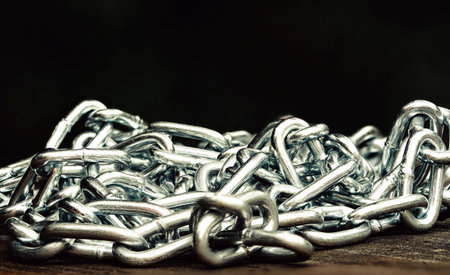 Metal shiny chain on a wooden surface close-upの写真素材
