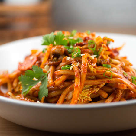 Spicy baby octopus stir fry with udon noodlesの写真素材