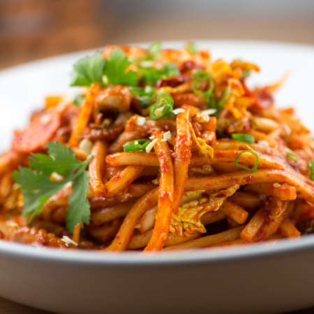 Spicy baby octopus stir fry with udon noodlesの写真素材