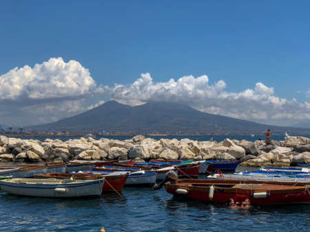 Sunbathers on the harbour in the Santa Lucia area of downtown Naples with a view over Mount Vesuvius in Naples, Italyのeditorial素材