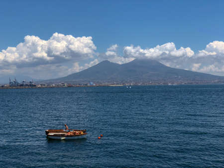 Sunbathers on the harbour in the Santa Lucia area of downtown Naples with a view over Mount Vesuvius in Naples, Italyのeditorial素材