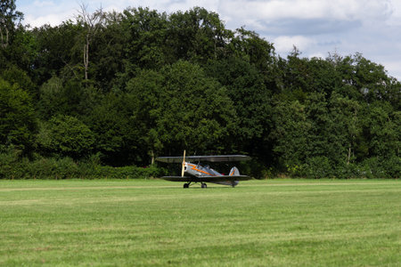 A small propeller plane is parked on a green grass field.の写真素材