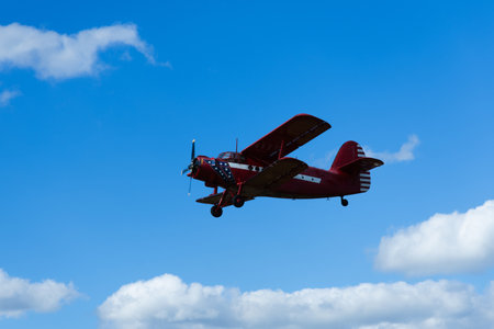 Plane in flight against a blue sky with white clouds in the air