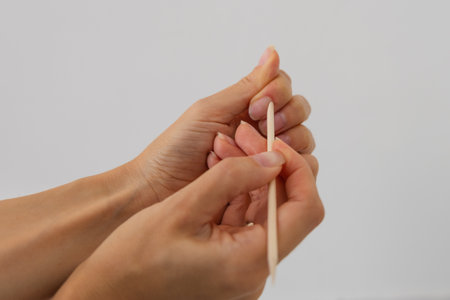 Female hands knitting with wooden knitting needles on white background, closeupの写真素材