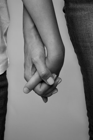 black and white photo of two people holding hands, closeupの写真素材