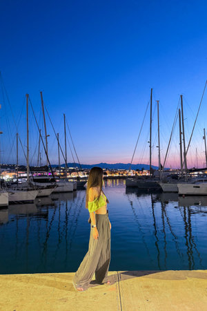 Beautiful young woman in the marina at sunset. Porto Rethymnon, Greeceの写真素材