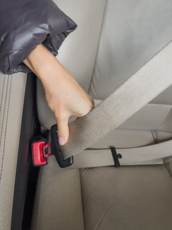 Close-up of a woman fastening a seat belt in a car safety belt and safety belt seat