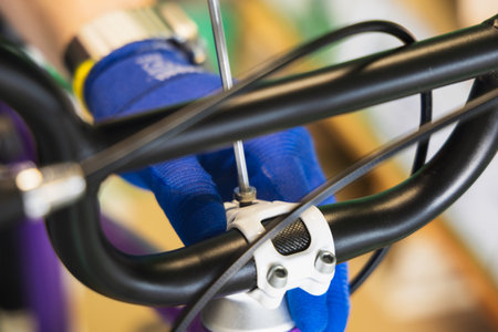 Close-up of a hand with a screwdriver repairing a bicycle.