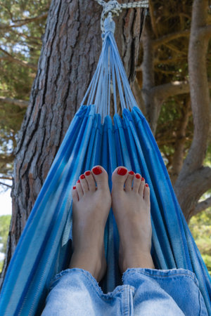 Close-up of a woman's feet relaxing in a hammockの写真素材
