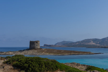 Beautiful view of ruined tower on La Pelosa beach Sardini Italy