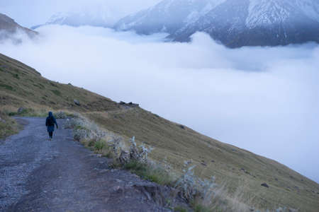 Aerial view of misty mountains at sunrise. Clouds drift amid rocky cliffs.の写真素材