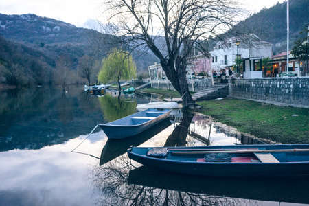 Wooden fishing boat in a still lake waterの写真素材