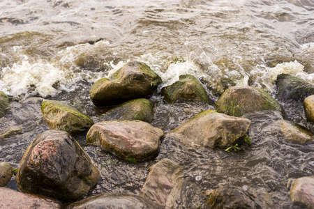 Sea stones and waves on the beach. background.の写真素材