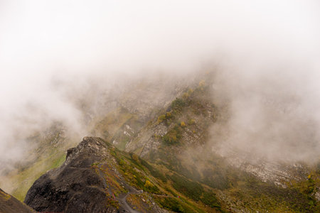 Mountain range with visible silhouettes through the morning colorful fog.の写真素材