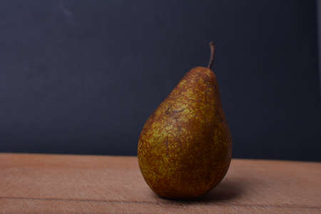 Pear on a wooden board. Pear on a dark background. Fresh fruit. Space for text.の写真素材