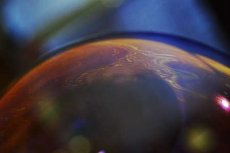 Soap bubble in macro multi-colored stains. Background out of focus