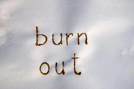 The words burn out have been burnt in white paperの写真素材