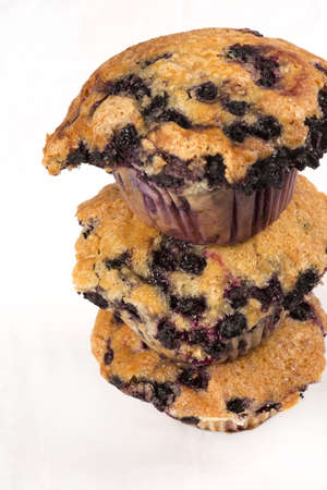 A trio of freshly baked blueberry muffins stacked on top of each otherA trio of freshly baked blueberry muffins stacked on top of each otherの写真素材