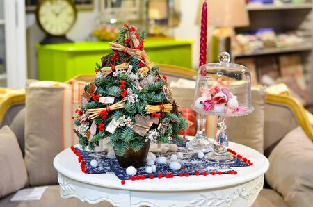 Little Christmas trees is on the table next to a candleの写真素材