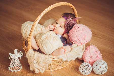 Cute newborn baby girl in a basketの写真素材