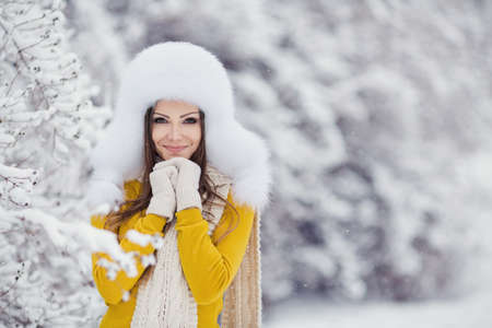 Beautiful winter portrait of young woman in the winter snowy sceneryの写真素材