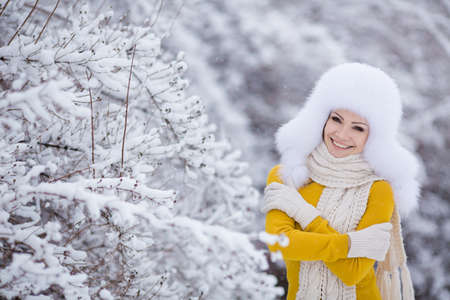 Beautiful winter portrait of young woman in the winter snowy sceneryの写真素材