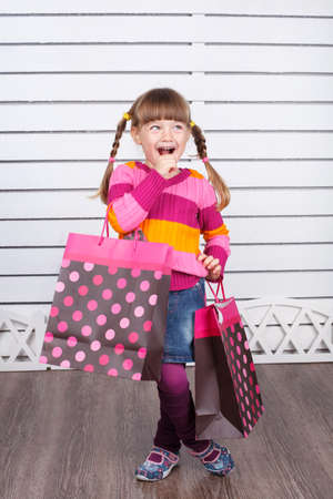 Happy child with shopping bags  She is enjoying the gifts and holidaysの写真素材