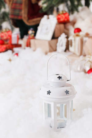 Christmas background with a red ornament, golden gift box, berries and fir in snowの写真素材