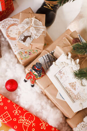 Christmas background with a red ornament, golden gift box, berries and fir in snowの写真素材