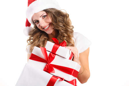 Christmas woman holding presents excited  Young happy woman wearing santa hat looking to side showing Christmas gift isolated on white background  Beautiful young santa woman の写真素材