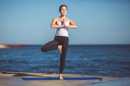 Healthy woman resting and curl up in fetal position outdoor at the sea  yoga pose  Series の写真素材