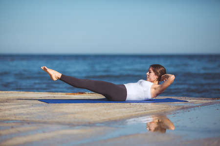 Healthy woman resting and curl up in fetal position outdoor at the sea  yoga pose  Series の写真素材