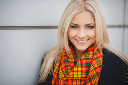 Portrait of beautiful young blonde woman walking outdoors in autumnの写真素材